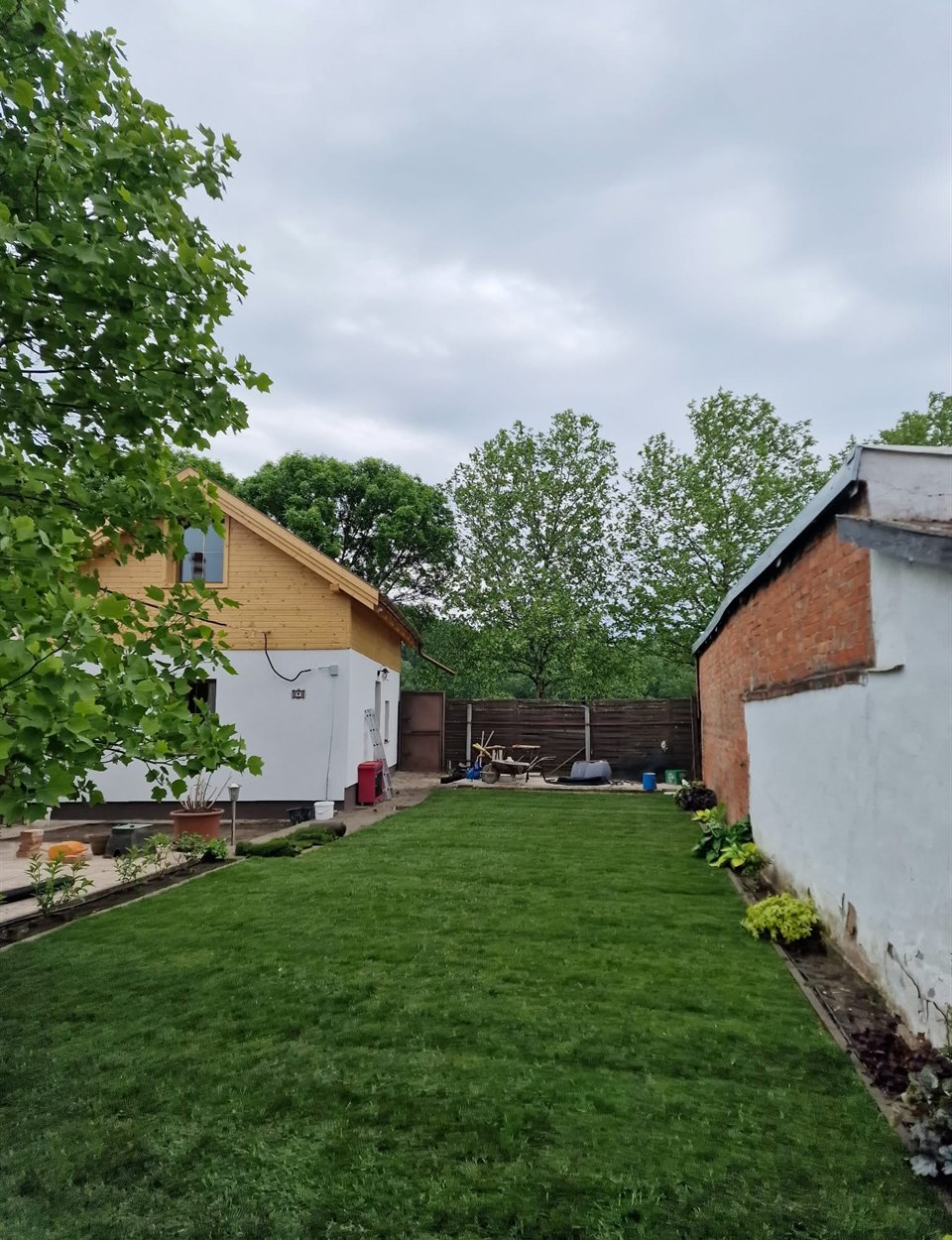 A ház melletti kertsáv kész, zöld gyeppel
